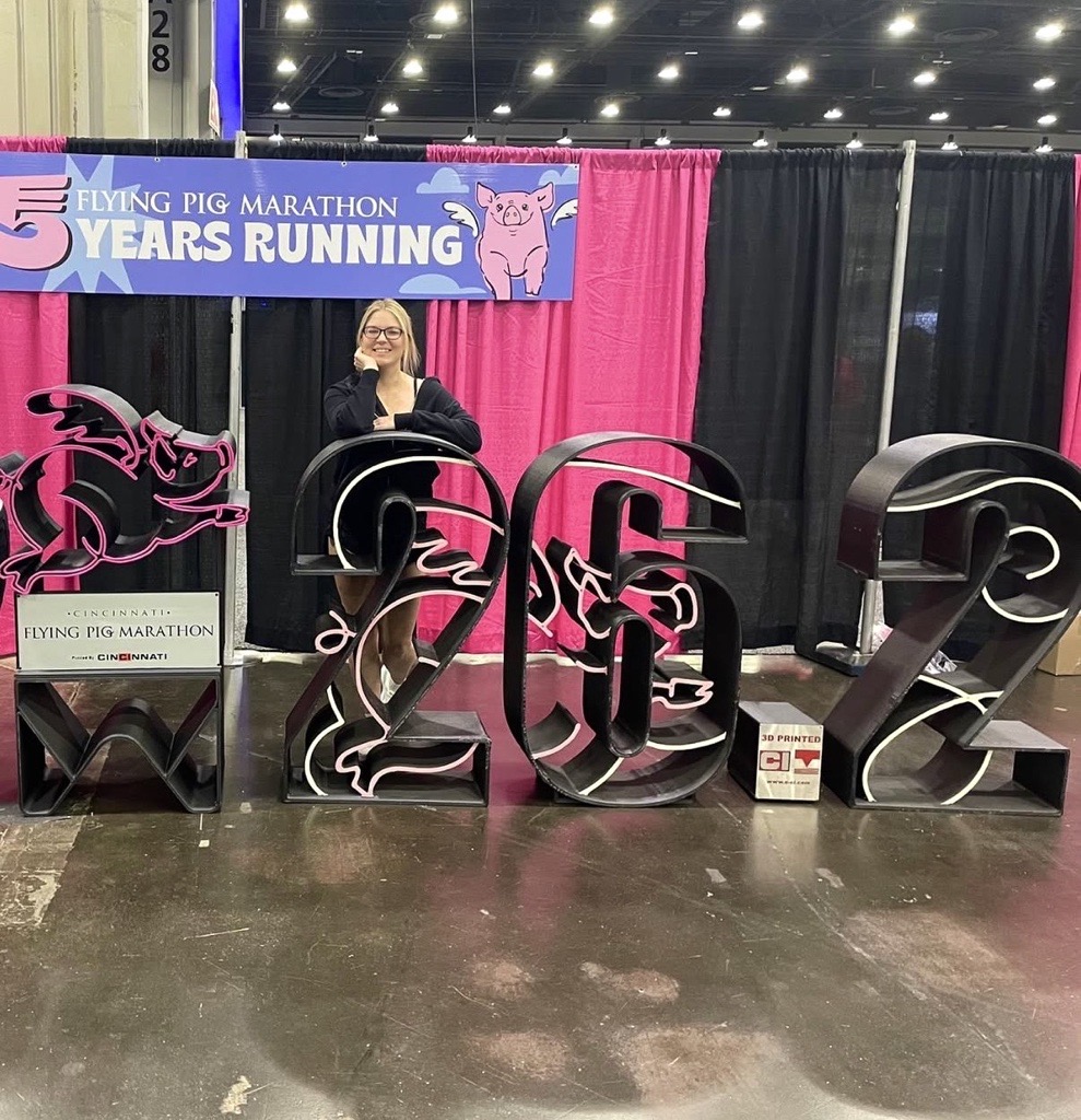 Marilee Cann posing with her medal in front of the 26.2 sign after completing the 2023 Flying Pig Marathon in Cincinnati, Ohio.